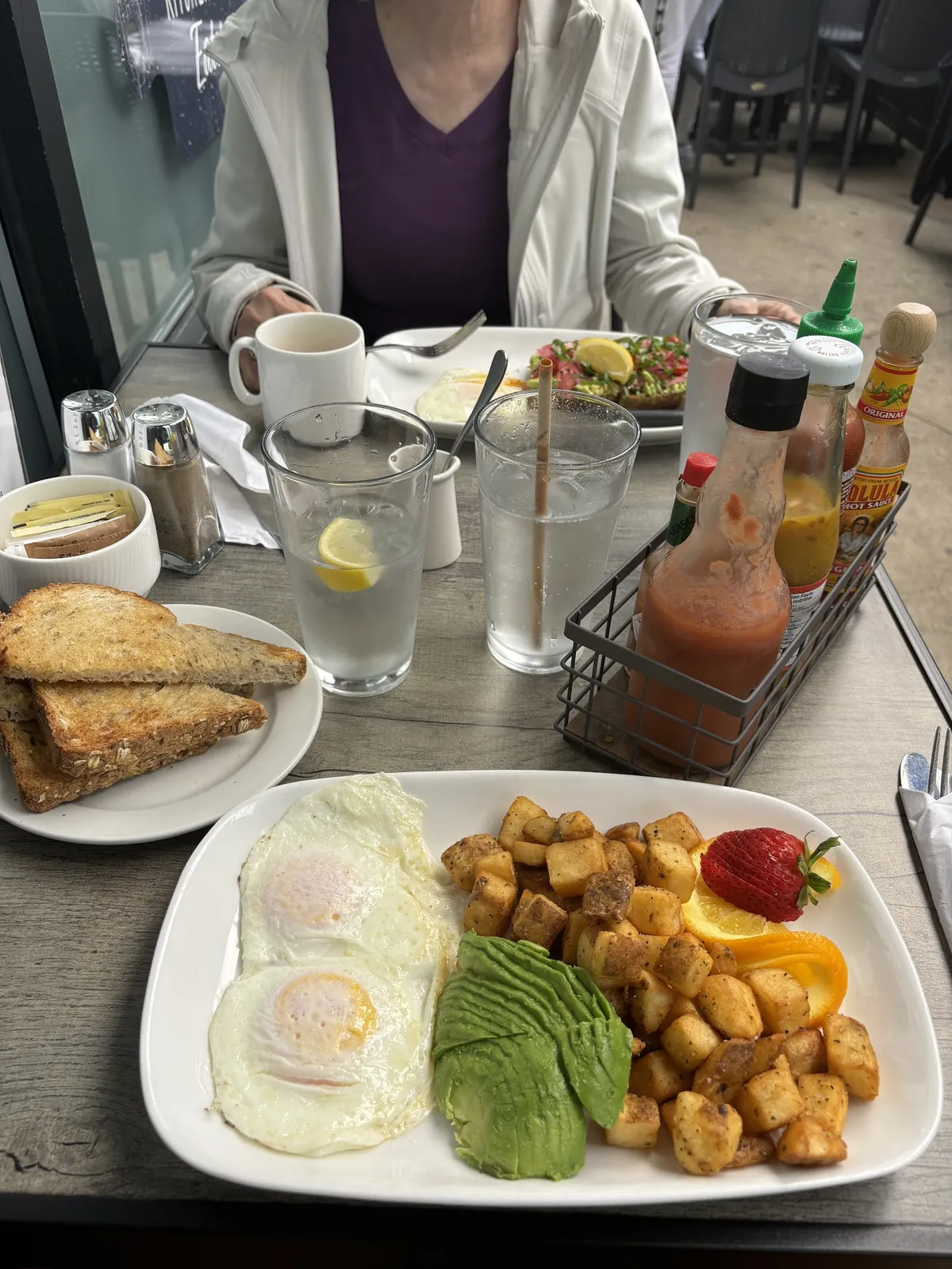 Breakfast plate with eggs, potatoes, avocado, and toast
